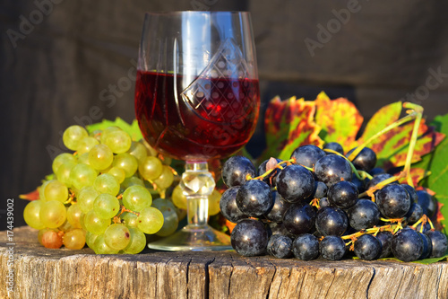 glass of wine and grapes on wooden