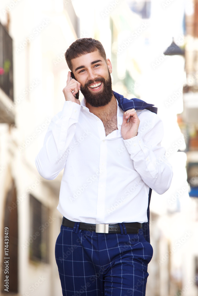 Happy businessman walking in city and talking on smart phone Happy businessman walking in city and talking on smart phone
