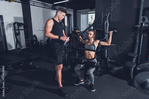 trainer and sportive woman in gym
