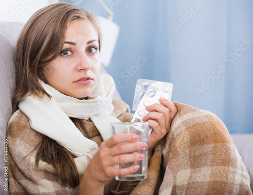 Canvas Print Ill girl on couch with drink and medicine