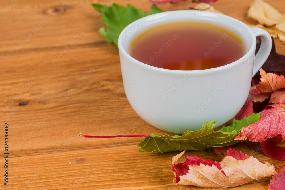 autumn foliage and tea cup on rustic garden table, close up shot autumn foliage and tea cup on rustic garden table, close up shot