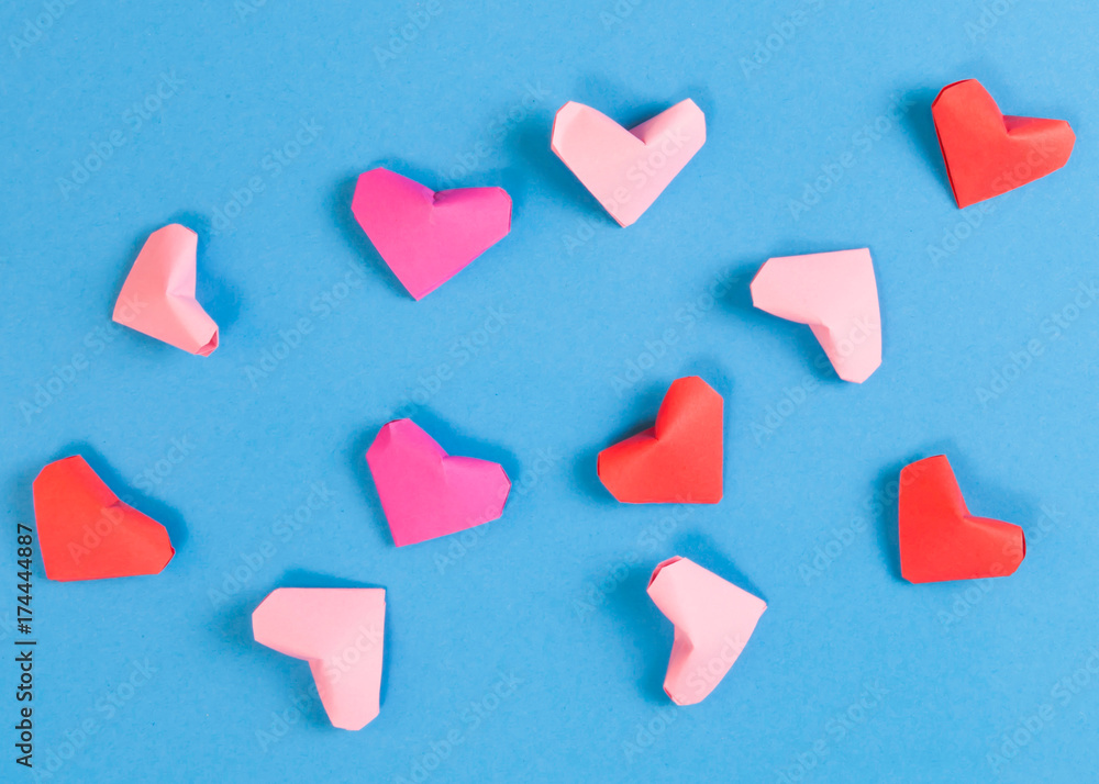 Red, Bright and Pale Pink Paper Origami Hearts on Blue Background Red, Bright and Pale Pink Paper Origami Hearts on Blue Background