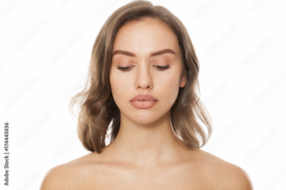 Portrait of beautiful young woman looking down on white background Portrait of beautiful young woman looking down on white background