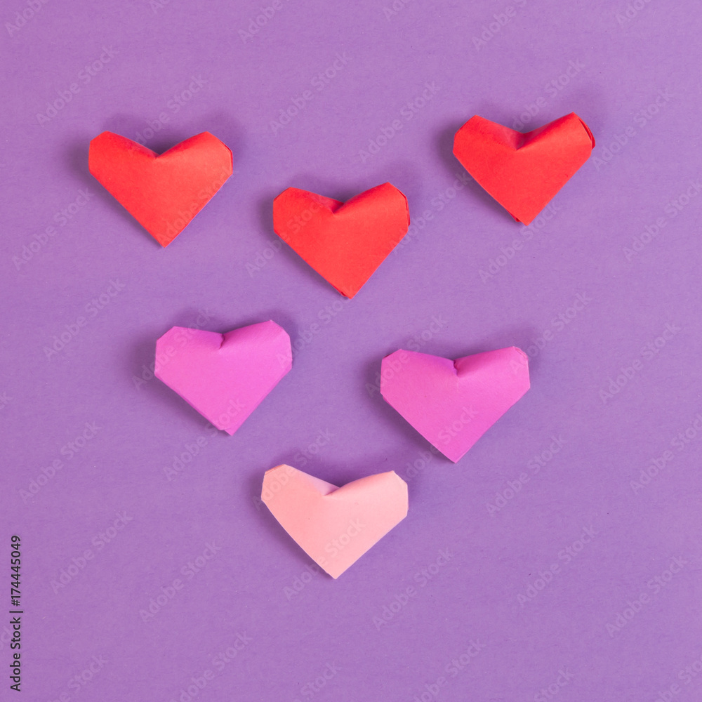 Red, Bright and Pale Pink Paper Origami Hearts on Purple Background Red, Bright and Pale Pink Paper Origami Hearts on Purple Background