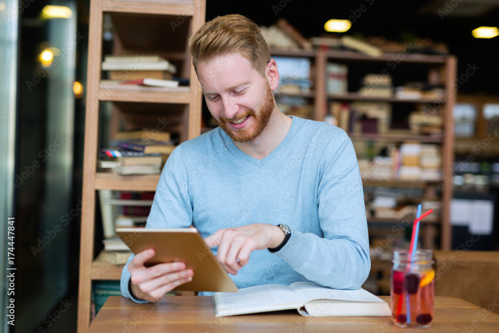 Young man using digital tablet in coffee shop Young man using digital tablet in coffee shop
