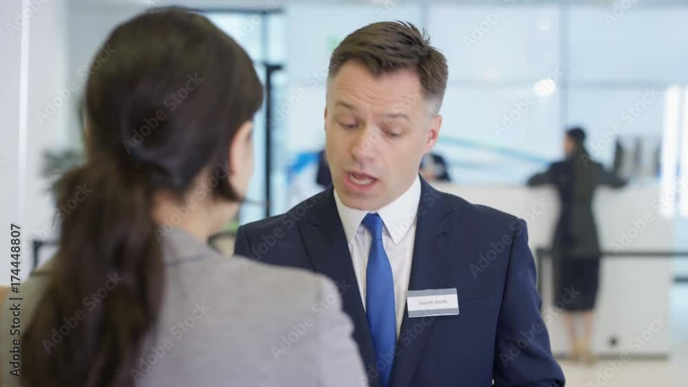Friendly bank workers talking to customers & offering financial advice Friendly bank workers talking to customers & offering financial advice