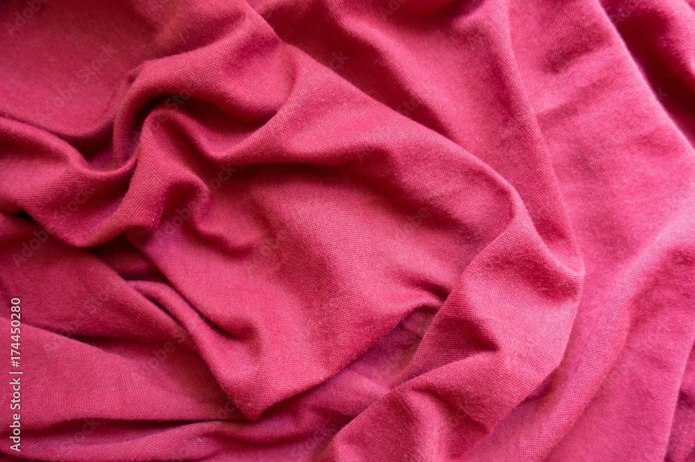 Ruby red cotton jersey fabric in soft folds Ruby red cotton jersey fabric in soft folds