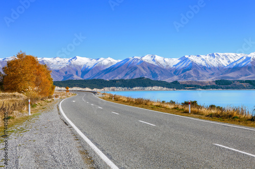 Scenic Road along Lake Tekapo at beautiful sunny morning . .Lake Tekapo and mountains with snow in autumn, Canterbury, South Island, New Zealand.