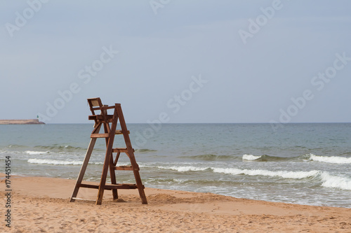 An empty lifeguard tower overlooking the ocean at the beach.
