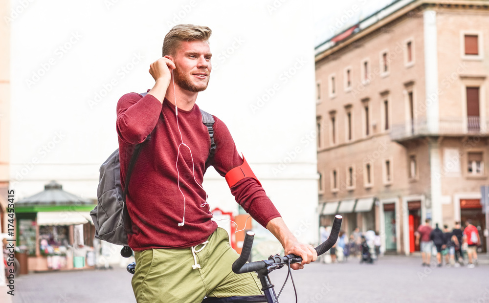 Young man with bicycle adjusting earphones - Commuter on bike making a phone call using headset - Healthy concept of green modern lifestyle Young man with bicycle adjusting earphones - Commuter on bike making a phone call using headset - Healthy concept of green modern lifestyle