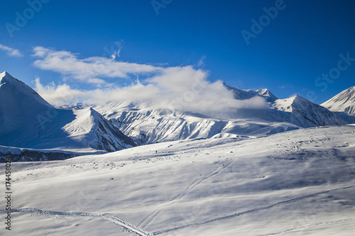 Mountain slope with peaks on the horizon. Clouds below the mountain peaks © Elena