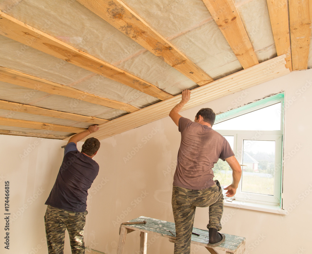 Fototapeta premium worker working on a wooden ceiling in the house