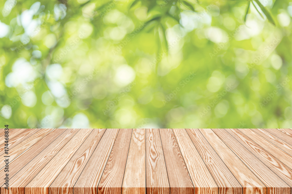 Wood table top on blur green abstract background from nature, can be used for display or montage your products.