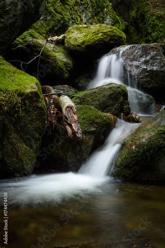 Fototapeta Naklejka Na Ścianę i Meble -  Waterfall and rocks covered with moss in the forest