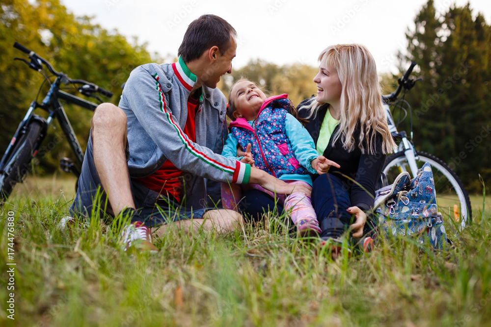 Fototapeta premium Happy family on bikes cycling outdoors active parents and kids on bicycles family sport and fun