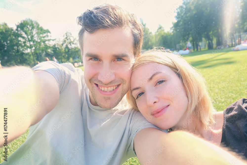 Fototapeta premium Young couple smiling while taking selfie