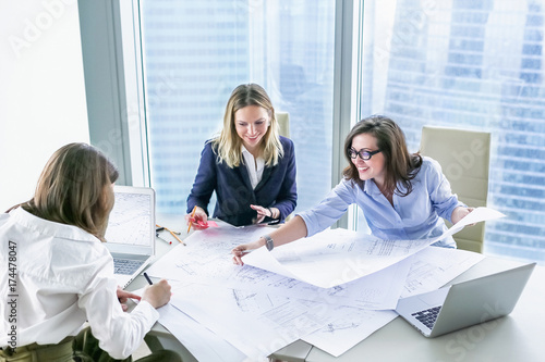 Business women working with business drawings in modern office
