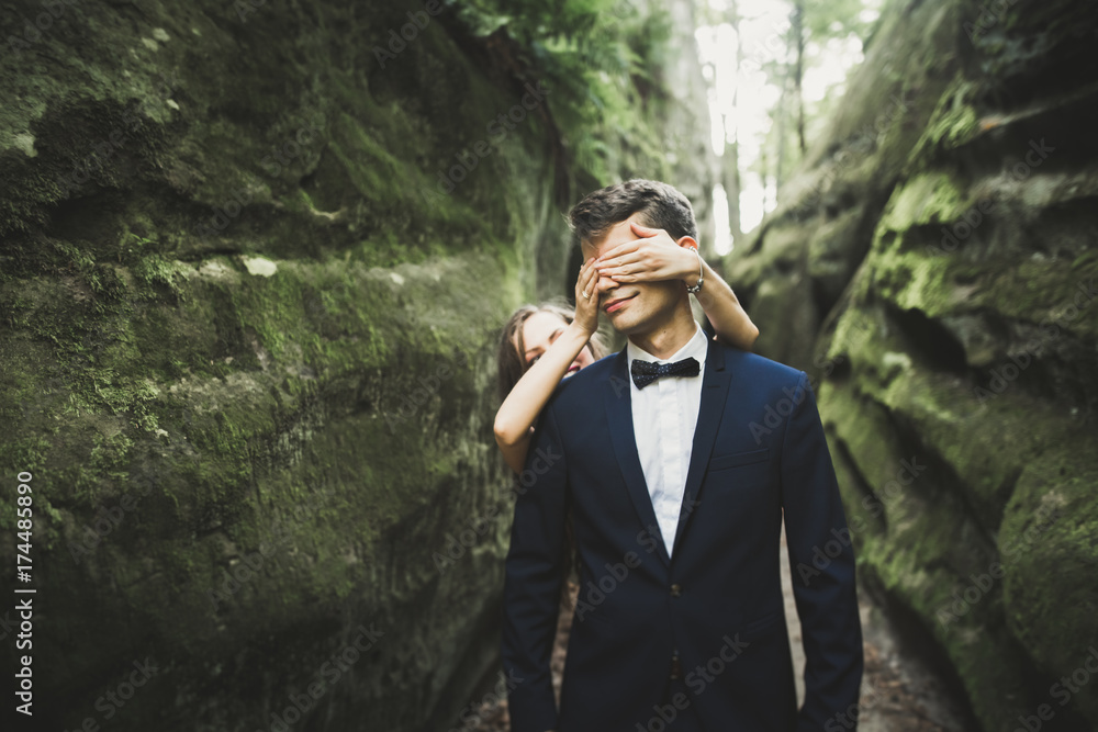 Happy wedding couple kissing and hugging near a high cliff Happy wedding couple kissing and hugging near a high cliff