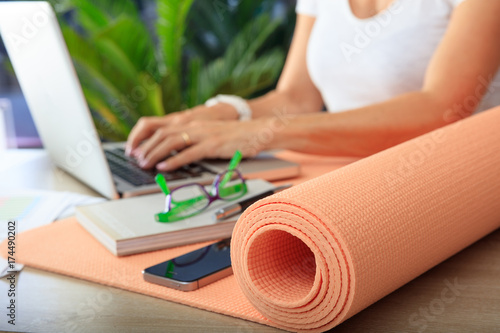 Woman and an exercise mat in an office background
