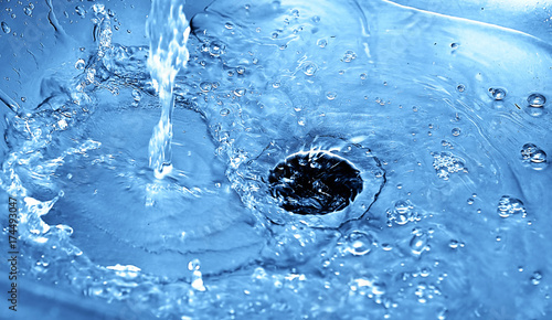 Water drain in stainless steel sink (blue tones)	