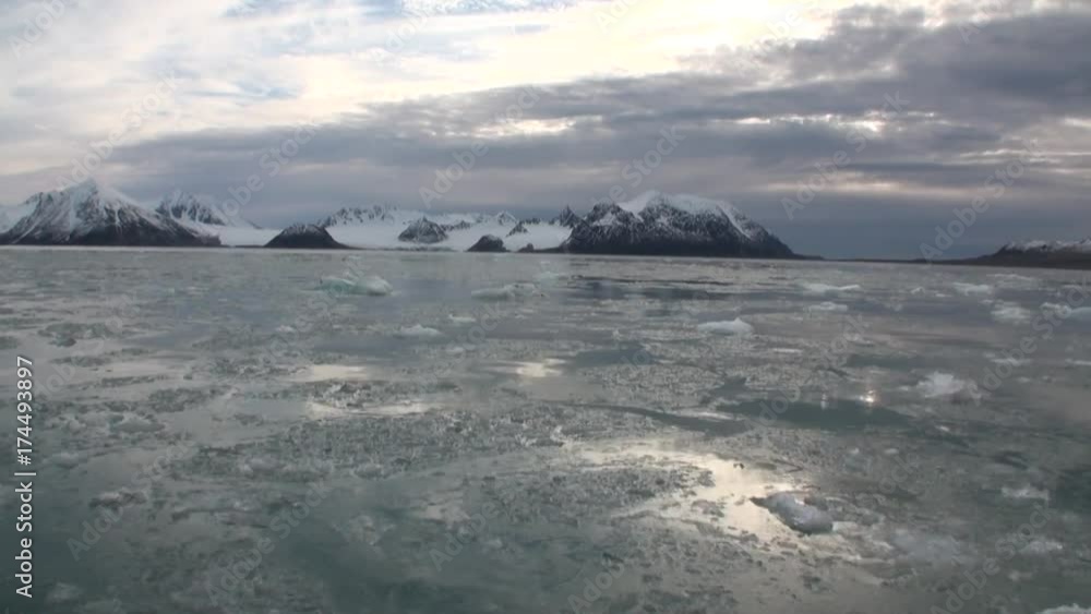 Moving Ice Floes on background snow mountains of Arctic Ocean in Svalbard. Wildlife in Nordic badlands. Unique footage and natural landscape of Spitsbergen. Moving Ice Floes on background snow mountains of Arctic Ocean in Svalbard. Wildlife in Nordic badlands. Unique footage and natural landscape of Spitsbergen.