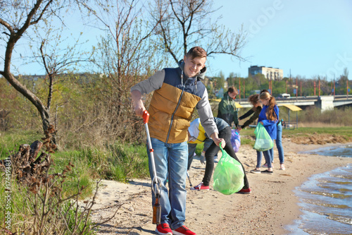 Young people cleaning beach area. Volunteering concept