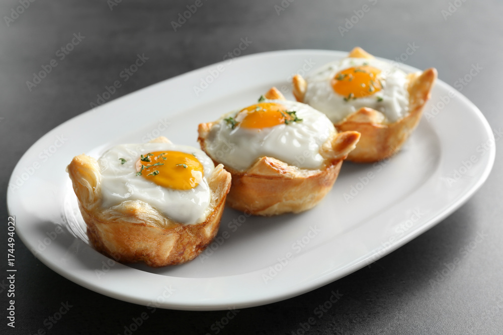 Tasty baked eggs in dough on plate