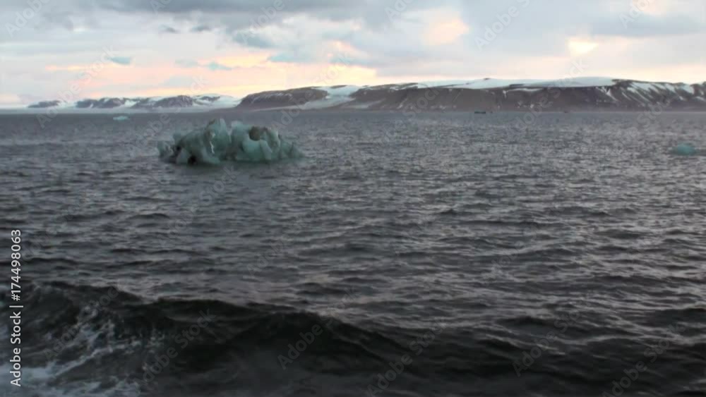 Snowy mountains and ice view from bow ship in Arctic Ocean on Spitsbergen. Beautiful landscape of wild nature. Quiet and calm ecotourism. Wildlife on background of desert. Snowy mountains and ice view from bow ship in Arctic Ocean on Spitsbergen. Beautiful landscape of wild nature. Quiet and calm ecotourism. Wildlife on background of desert.