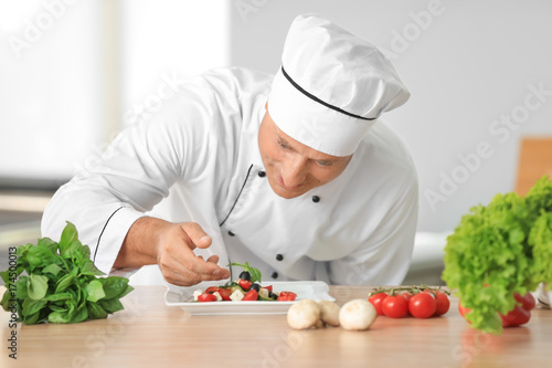 Male chef making salad in kitchen
