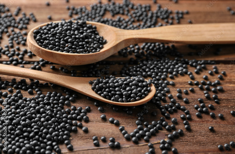 Spoons with healthy lentils on wooden background Spoons with healthy lentils on wooden background