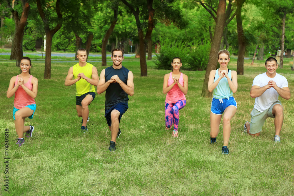Fototapeta premium Group of young people doing exercise outdoors
