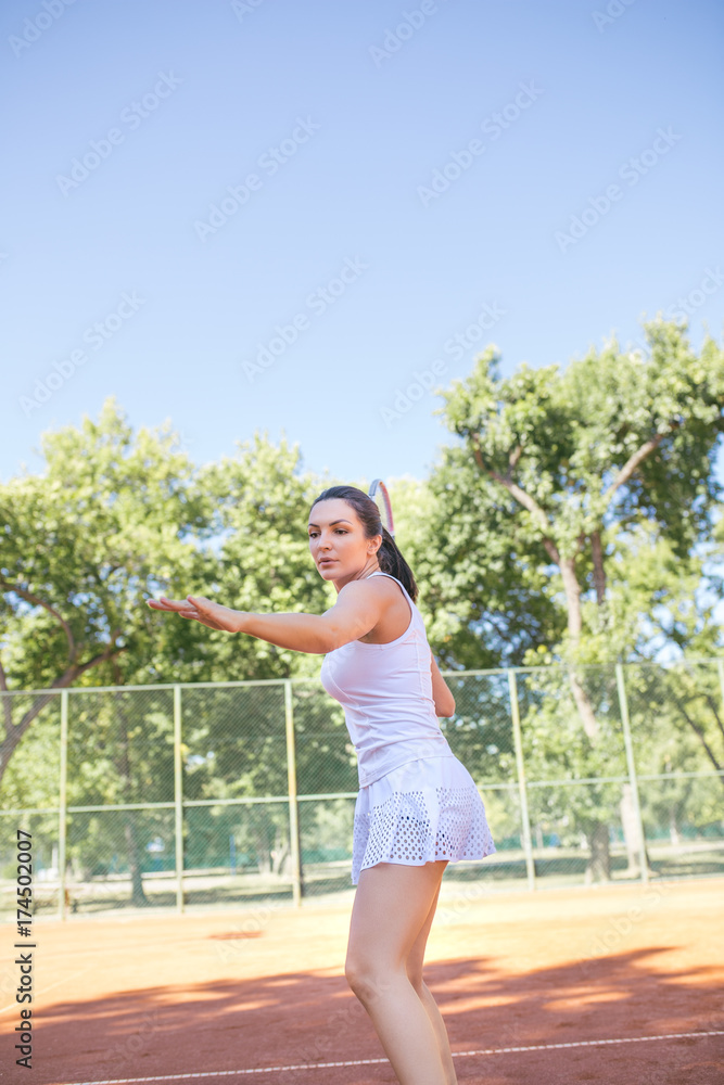 Portrait of beautiful young woman playing tennis.