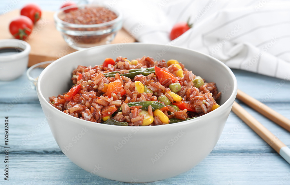 Bowl with brown rice and vegetables on table, closeup Bowl with brown rice and vegetables on table, closeup