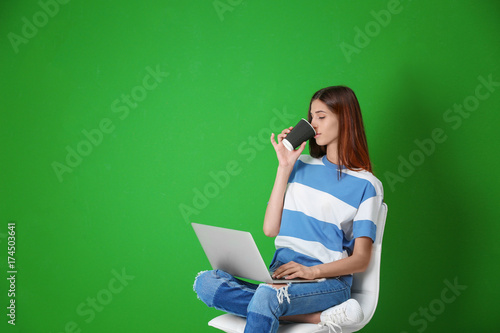 Young woman with laptop on ...