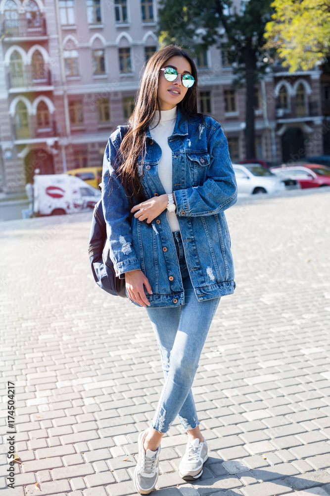 Tame inherit honor Hipster girl wearing blank gray t-shirt, jeans and backpack posing against  rough street wall, minimalist urban clothing style.Stylish happy young  woman wearing boyfriend jeans and long jeans coat Stock Photo | Adobe
