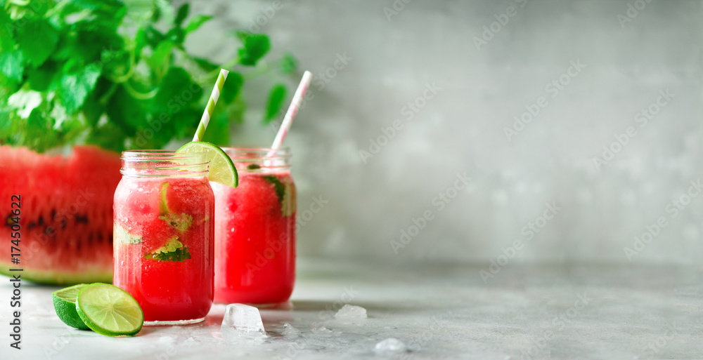 Fresh red watermelon slice and smoothie in glass jar with straw, ice, mint, lime on light background, copy space - obrazy, fototapety, plakaty 