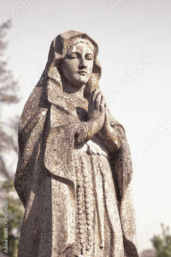 Virgin Mary statue. Vintage sculpture of sad woman in grief (Religion, faith, suffering, love concept)