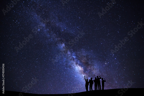 Landscape with milky way galaxy, Starry night sky with stars and silhouette of people standing happy man on high mountain.