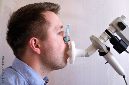 Tablou pe pânză Young man testing breathing function by spirometry