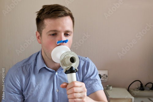 фотографія Young man testing breathing function by spirometry
