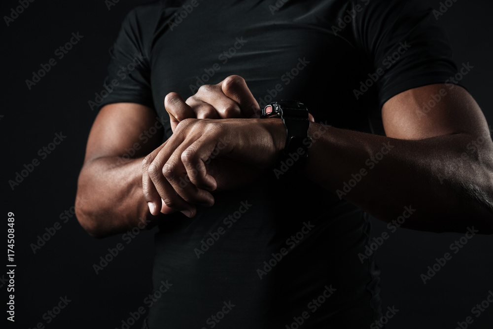Close-up photo of african man in black t-shirt check out time at black wristwatch