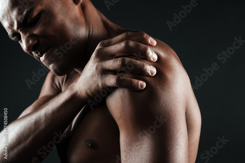 Quadro su tela Cropped photo of young shirtless afro american man with shoulder pain