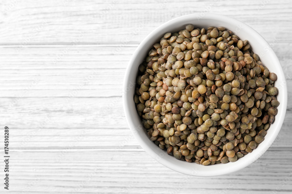 Bowl with black lentils on wooden background Bowl with black lentils on wooden background