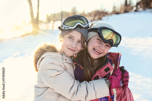 Young smiling girls play on a winter sunny day