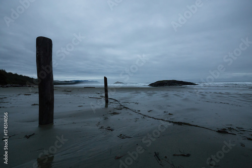 Beautiful moody view on the sandy beach on the Pacific West Coast during a cloudy early morning. Taken in Tofino, Vancouver Island, British Columbia, Canada.