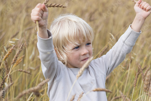 Obraz na płótnie Blond Slavic happy kid boy at a ripe rye wheat field, autumn harvest, Russia, the Urals w salonie