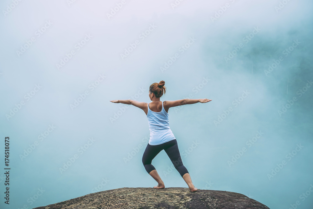 Asian women relax in the holiday. Play if yoga. On the Moutain rock cliff Asian women relax in the holiday. Play if yoga. On the Moutain rock cliff