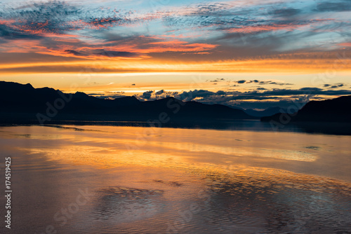 Alaskan coastline sunset with mountain silhouette