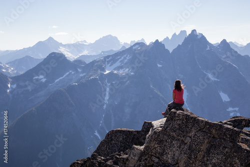 Woman enjoying the beautiful Canadian Mountain Landscape view on top of the peak. Taken on top of MacDonald Peak near Chilliwack, East of Vancouver, BC, Canada.