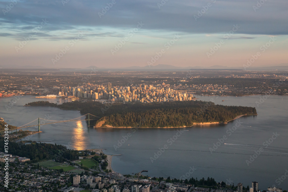 Aerial view of Stanley Park and Downtown City during a vibrant sunset. Taken in Vancouver, British Columbia, Canada.